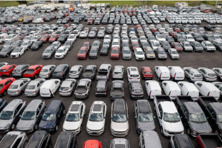 Large automotive remarketing lot with rows of passenger vehicles