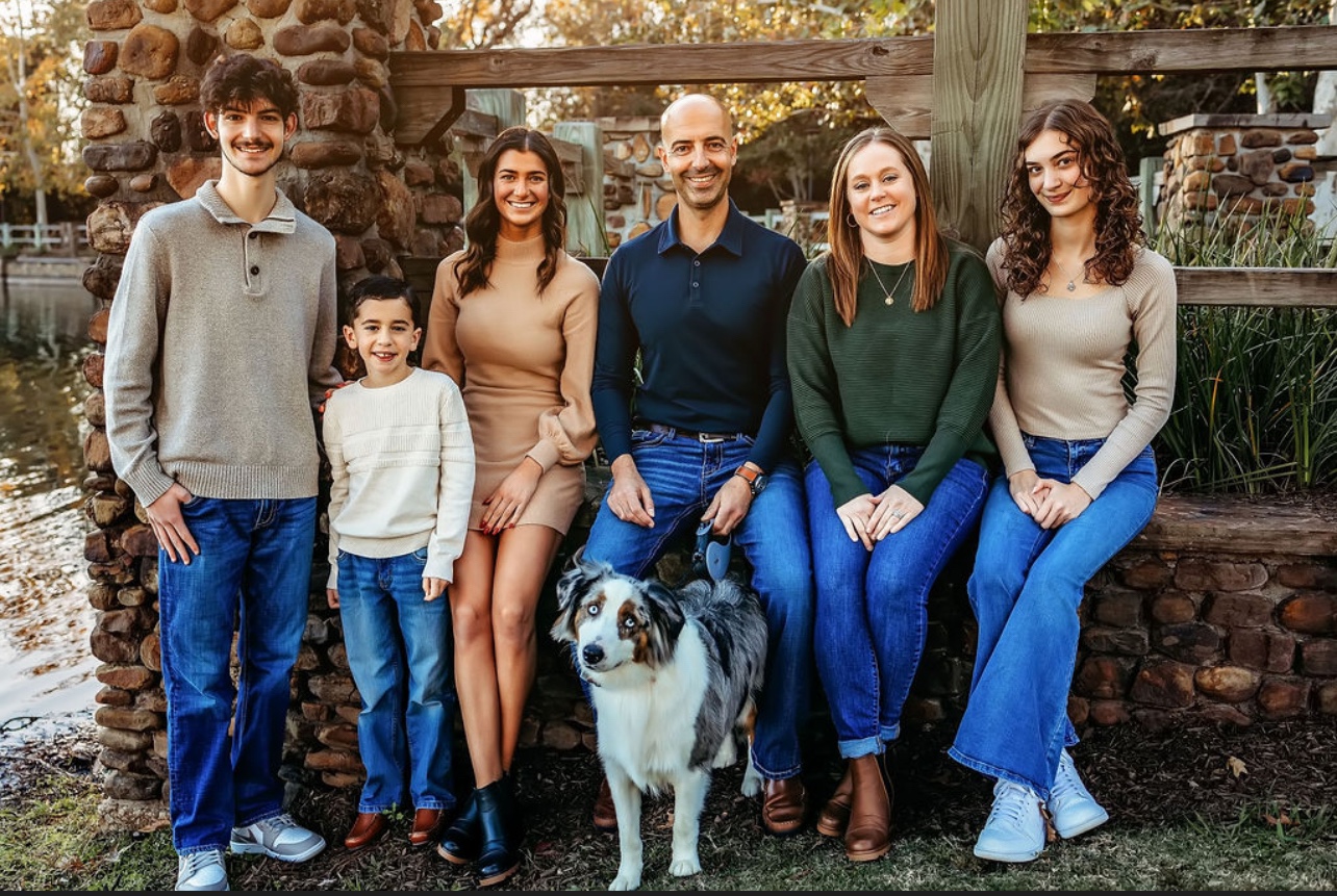 Nick Abueita with his family and dog in an outdoor family portrait